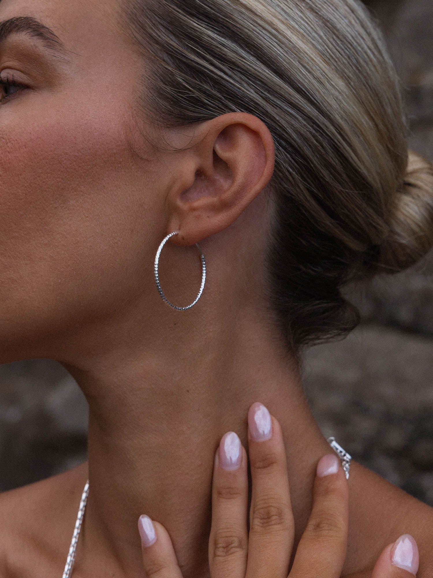 Gleam Ohrringe aus recyceltem Silber mit facettierter Oberfläche, elegant getragen, pure PURELEI Ästhetik.