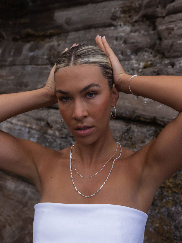 Perfection Kette aus recyceltem Silber mit schimmernder Süßwasserperle, getragen vor Felskulisse – PURELEI.