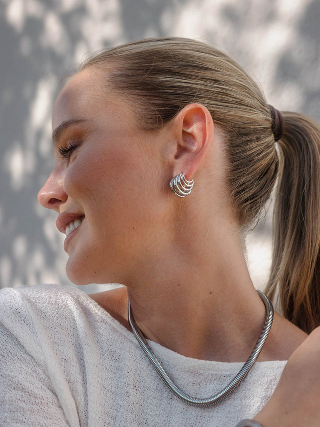 Silberne Creolen und Kette von PURELEI, elegant und modern, strahlen zeitlose Schönheit aus.