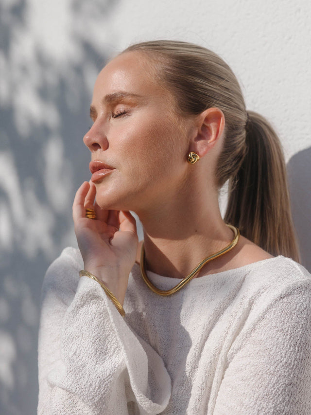 Roségoldenes PURELEI Halsband und Ohrringe, elegant und feminin, in warmem Licht.