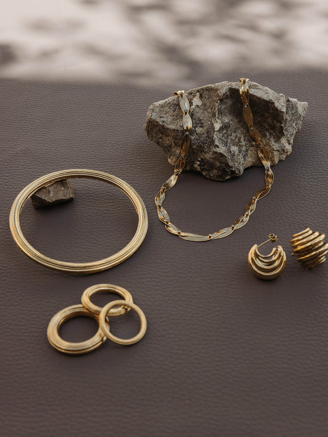 Silberne Schmuckstücke von PURELEI auf dunklem Untergrund, elegant und modern.