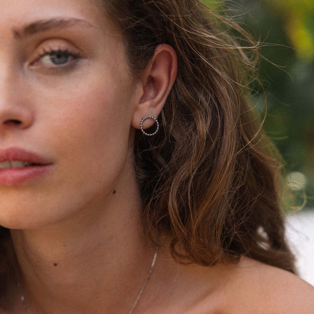 Goldene Creolen mit strukturierter Oberfläche, getragen von einer Frau, PURELEI.