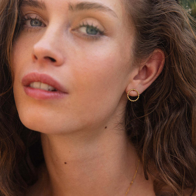 Roségoldene Creolen mit Perlen-Detail, getragen von einer Frau, PURELEI inspiriert.