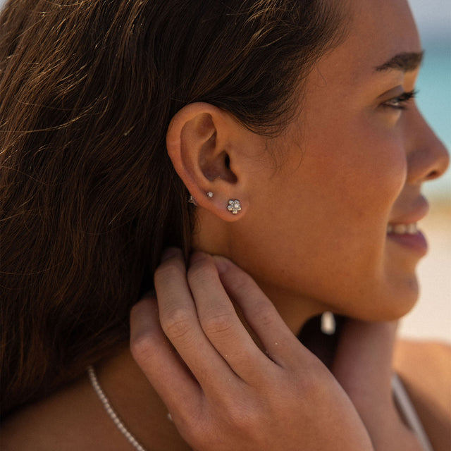 Silberne Ohrringe mit floralen Motiven, getragen von einer Frau, PURELEI inspiriert.