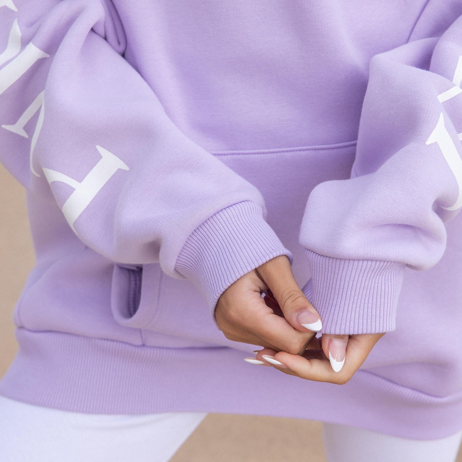 Locker sitzender lila PURELEI Hoodie aus Baumwollmix mit weißem Schriftzug auf den Ärmeln, casual und bequem.