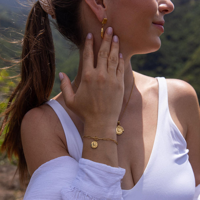 Roségoldenes Armband und Ohrringe von PURELEI, elegant und feminin, getragen in natürlicher Umgebung.