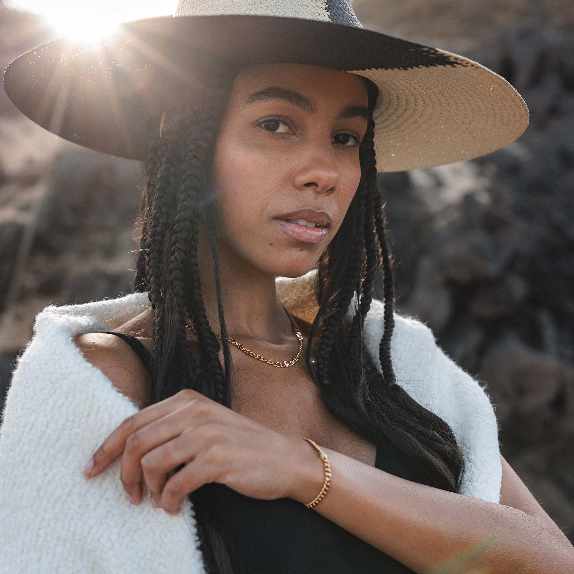 Elegante PURELEI Kette und Armband, silberfarben, getragen mit einem Hut in warmem Licht.