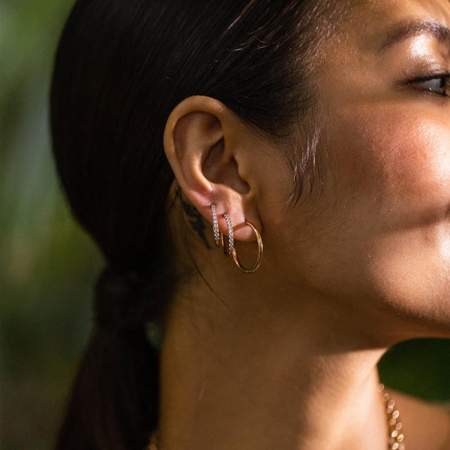 Roségoldene Creolen und Ohrstecker von PURELEI, elegant und feminin, im warmen Licht.