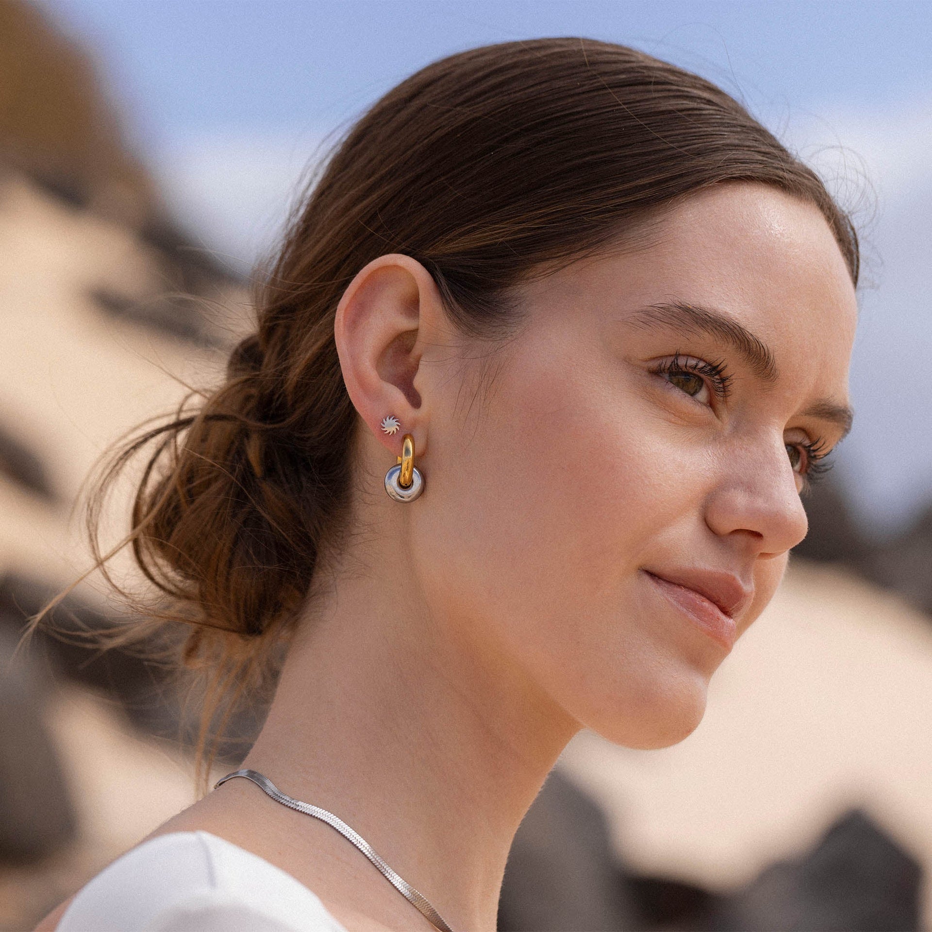 Roségoldene und silberne Creolen von PURELEI, elegant und modern, strahlen feminine Leichtigkeit aus.