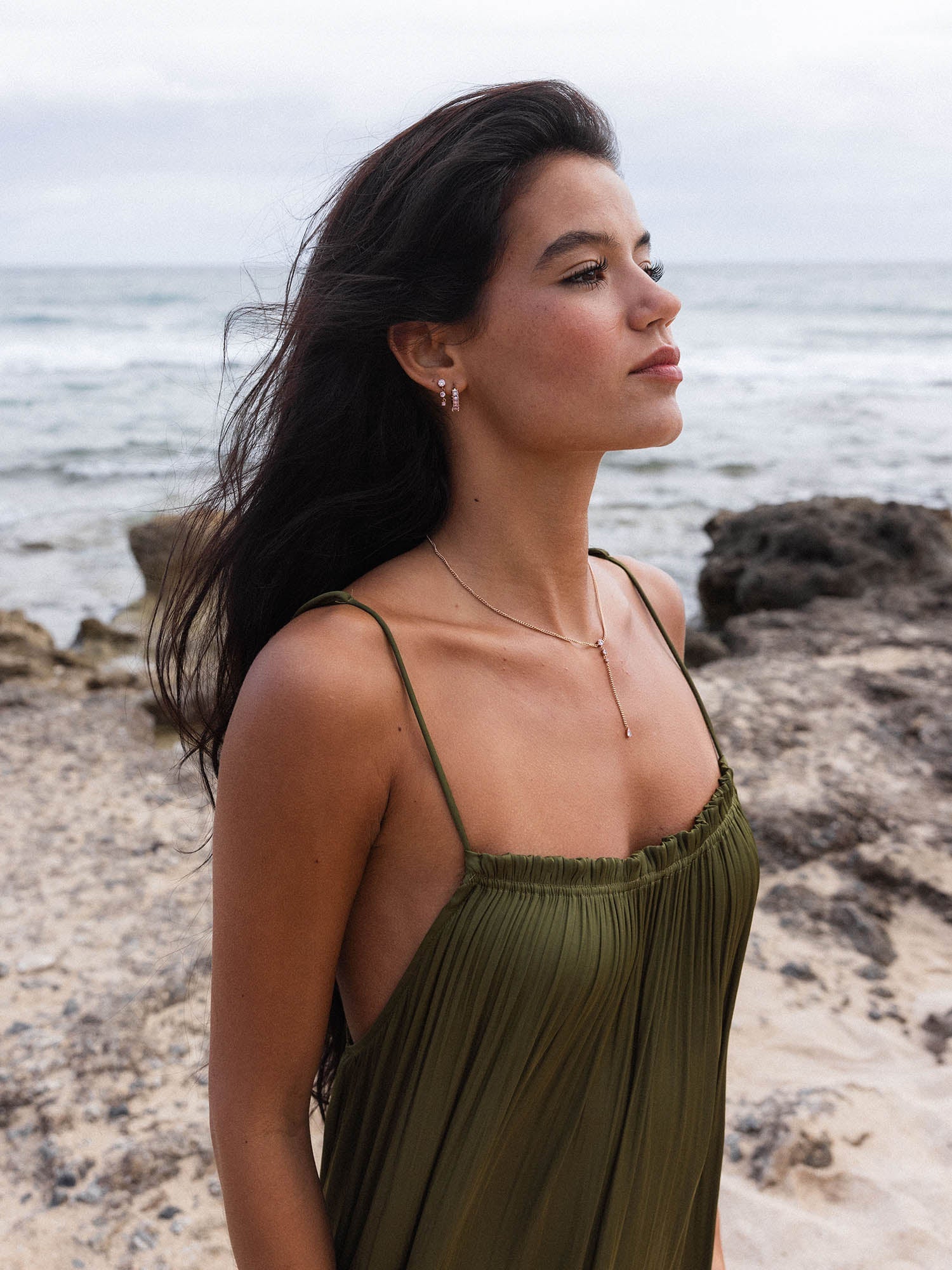 Elegante PURELEI Kette mit zartem Anhänger, getragen am Strand, umgeben von natürlicher Schönheit.