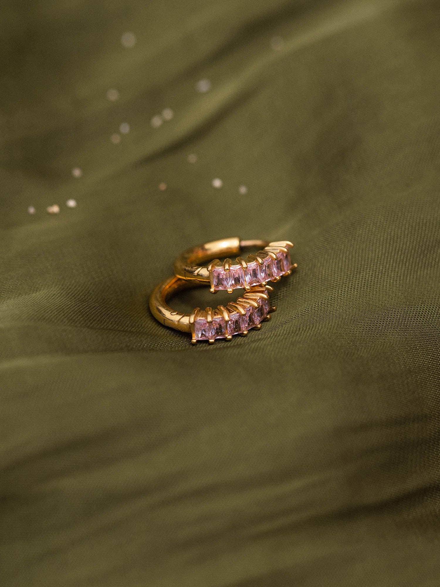 Silberne Creolen mit funkelnden Steinen auf sanftem Stoff, PURELEI Eleganz.