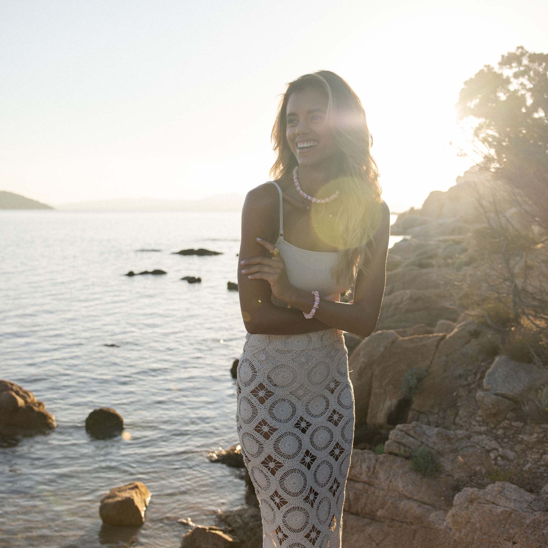 Kalea Shell Kette von PURELEI mit goldenen Muschel-Anhängern, getragen am sonnigen Küstenufer – elegant und feminin.