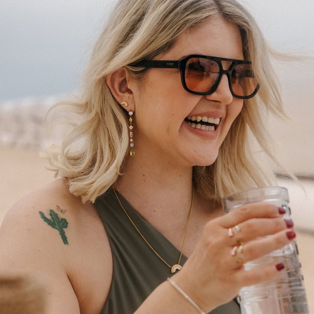 Elegante Ohrringe mit funkelnden Details, getragen von einer lächelnden Frau, PURELEI.