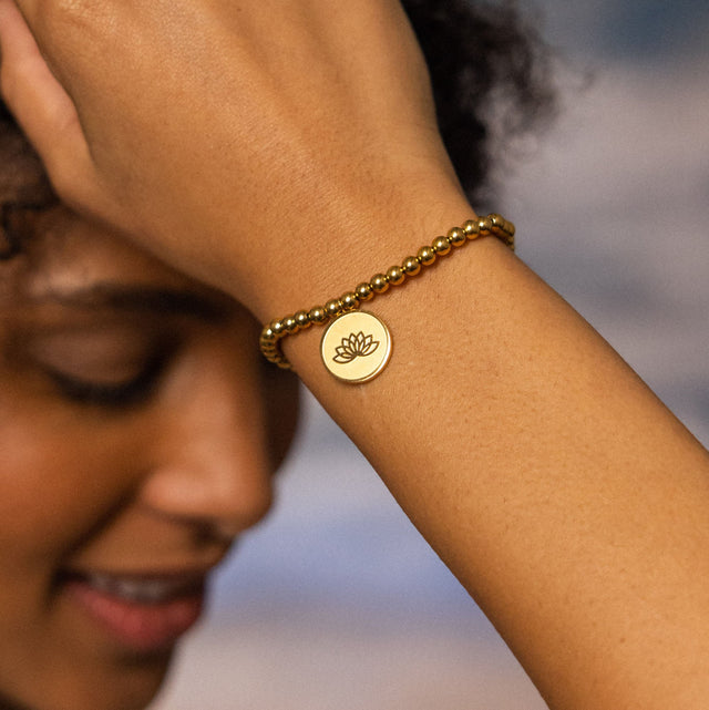 Roségoldenes Armband mit Lotus-Anhänger, getragen am Handgelenk, von PURELEI.