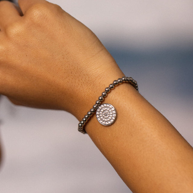 Elegantes Armband mit Kristall-Anhänger, PURELEI, auf braunem Handgelenk.