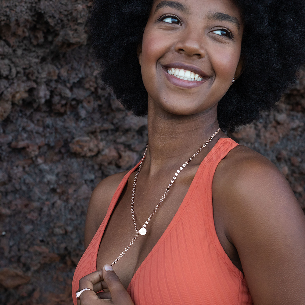 PURELEI Pure Kette in 18K Gold, verstellbar und nickelfrei, getragen vor natürlichem Lavahintergrund, elegant und feminin.