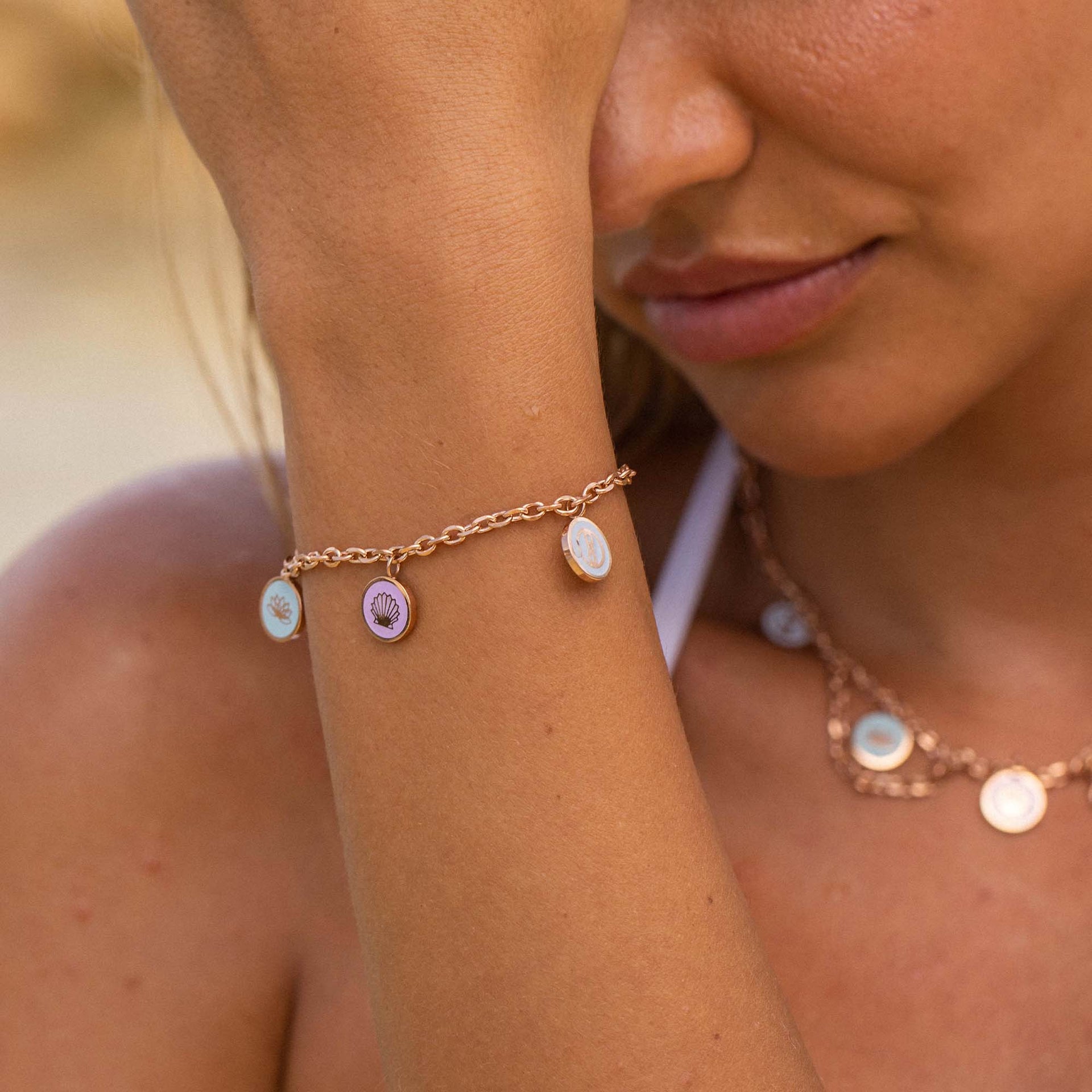 Silbernes Armband mit Muschel-Anhängern, getragen am Handgelenk, PURELEI Stil.