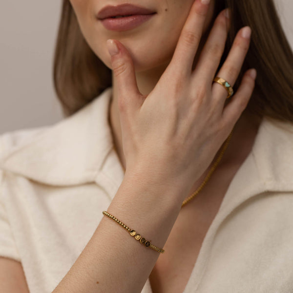 Roségoldenes Armband mit runden Details, getragen mit eleganter Ausstrahlung, von PURELEI.