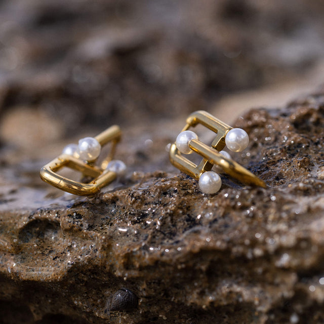 Glace Ohrringe von PURELEI, goldene Edelstahlcreolen mit Muschelperlen, elegant auf natürlichem Stein – feminine Leichtigkeit.