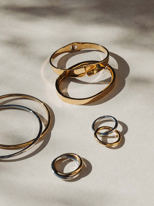 PURELEI Embrace Armcuff aus poliertem Gold und Silber, elegant und zeitlos auf hellem Hintergrund inszeniert