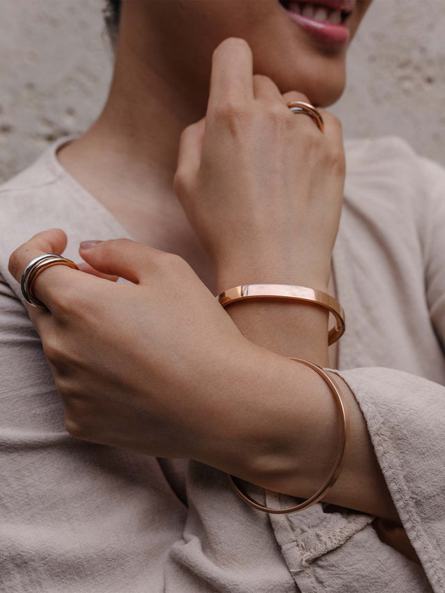 Elegante, roségoldene Armbänder und Ringe von PURELEI, getragen mit einem lässigen Outfit.