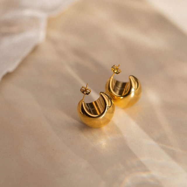 Goldene Creolen von PURELEI mit glänzender Oberfläche, elegant und feminin.