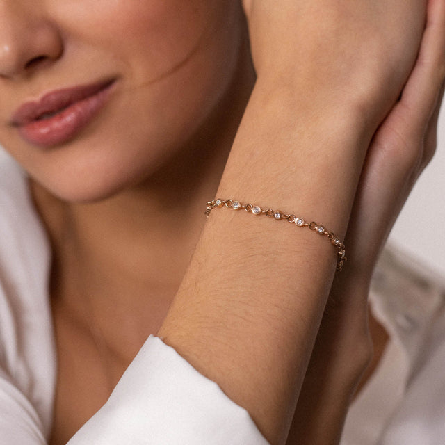 Roségoldenes Armband mit funkelnden Steinen, getragen am Handgelenk, PURELEI.