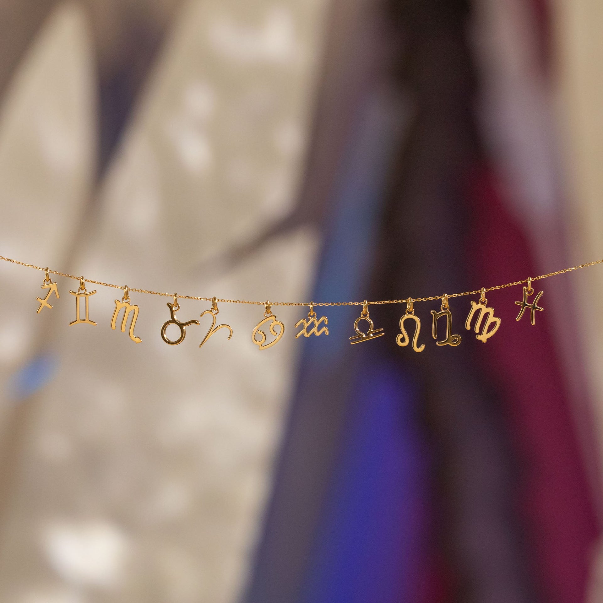 PURELEI Fische Zodiac Charm in 18K Gold, filigranes Sternzeichen-Design, elegant inszeniert mit warmem Insel-Flair