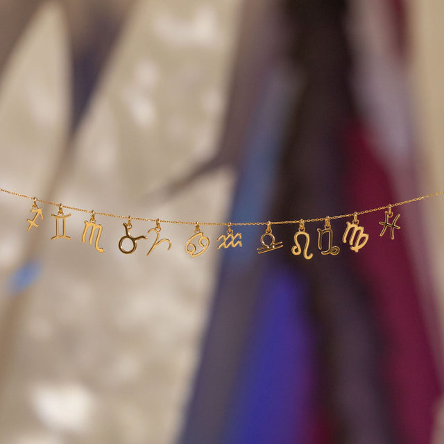 PURELEI Fische Zodiac Charm in 18K Gold, filigranes Sternzeichen-Design, elegant inszeniert mit warmem Insel-Flair